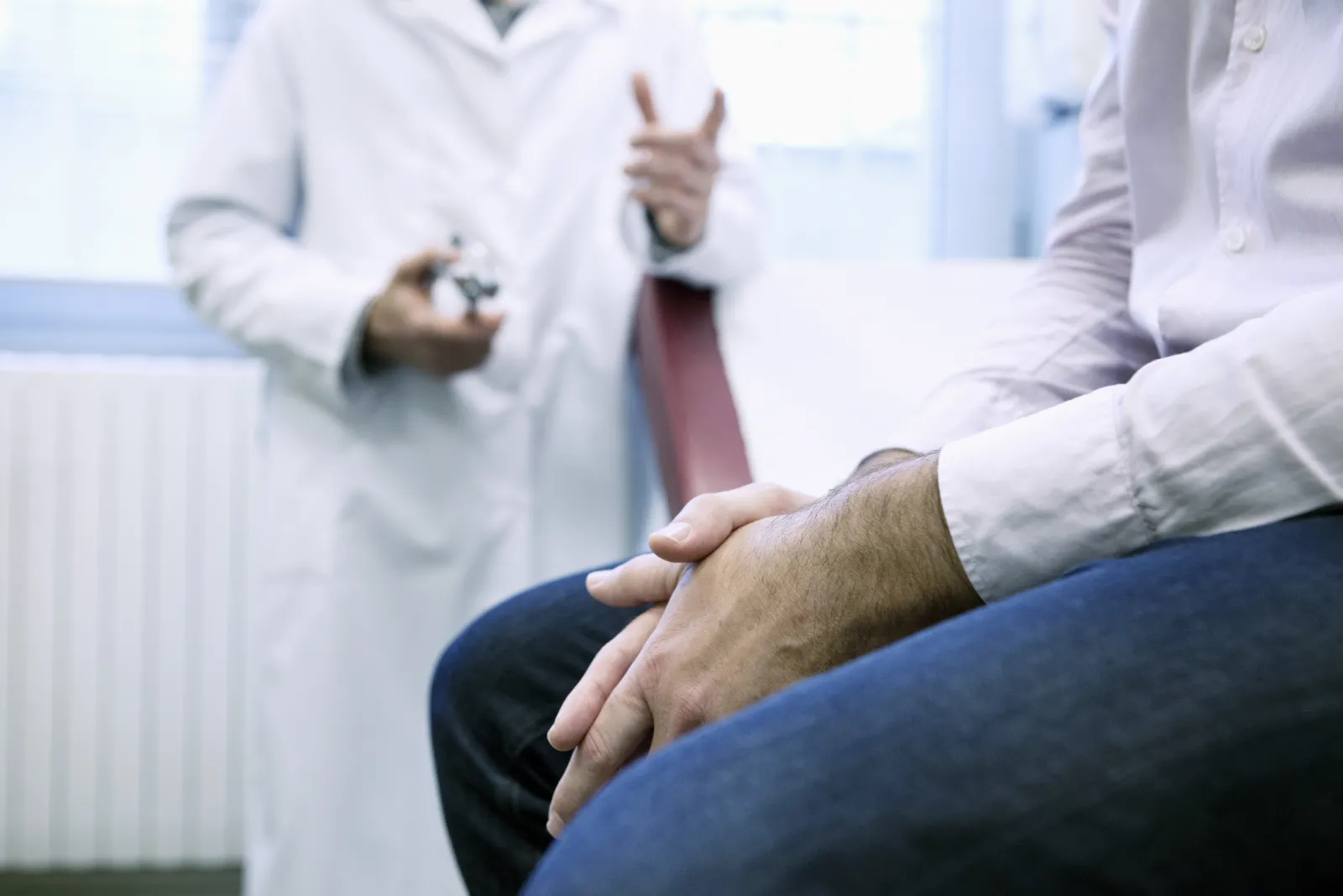 A physician consults with a patient in an exam room.