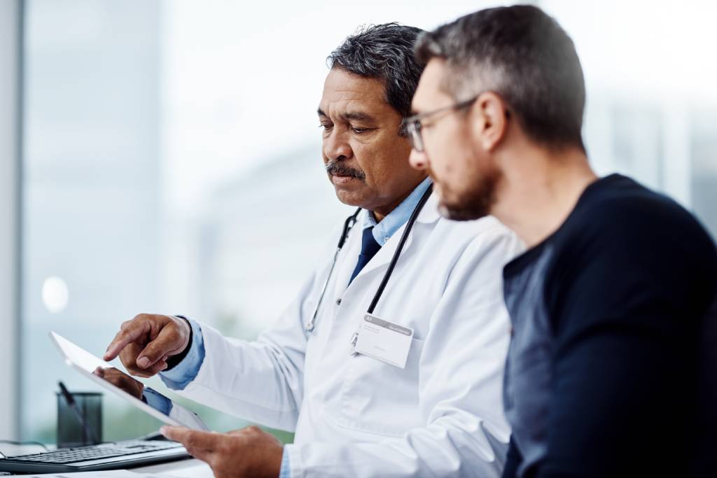 A physician reviews test results with a patient.