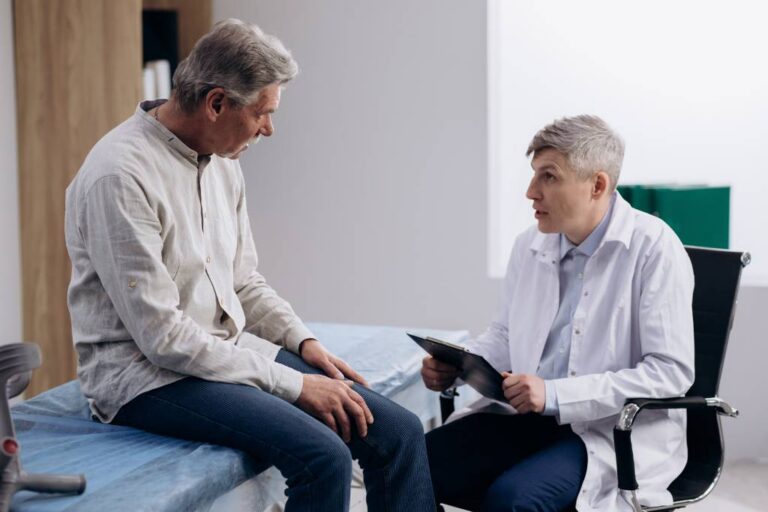 A physician speaks to a patient in an exam room.