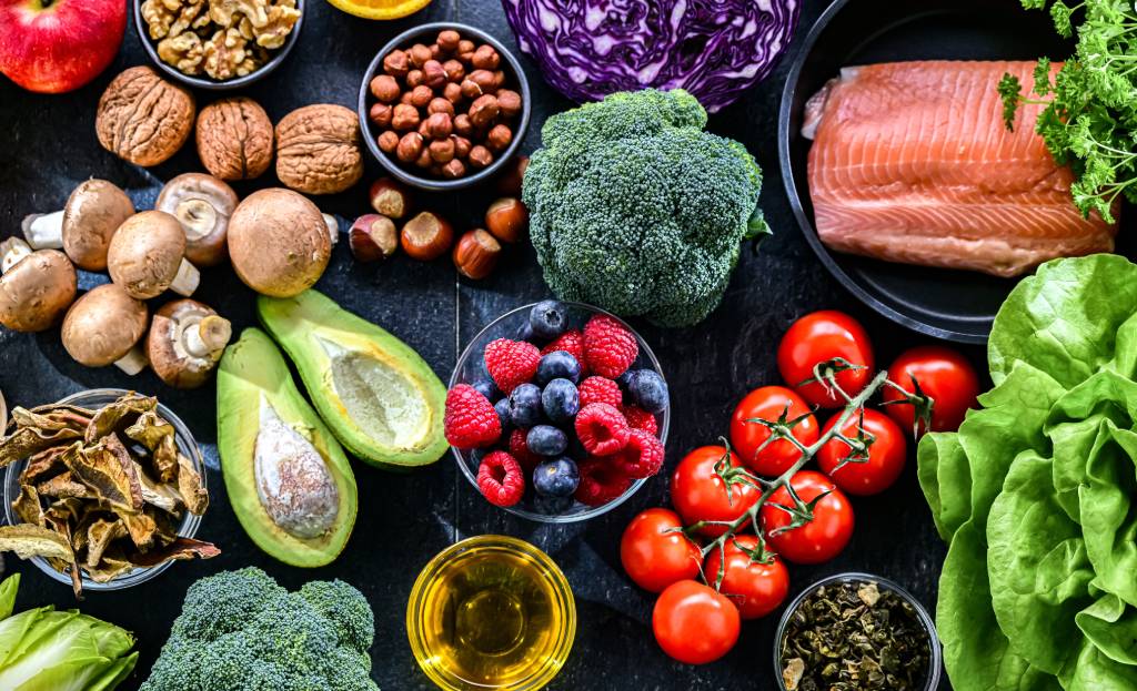 A variety of low-inflammation foods are seen on a stone table.