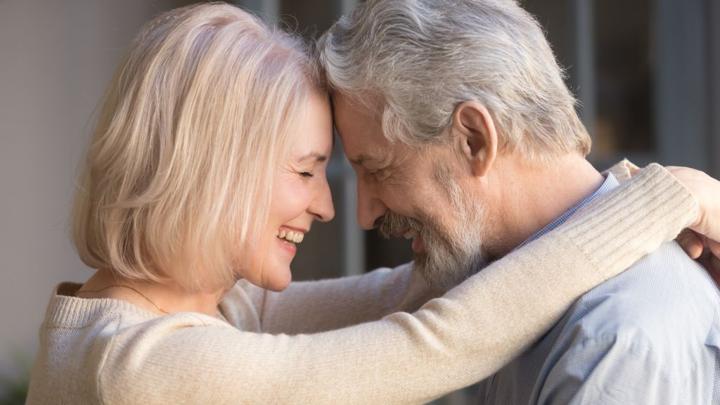An older couple embraces.